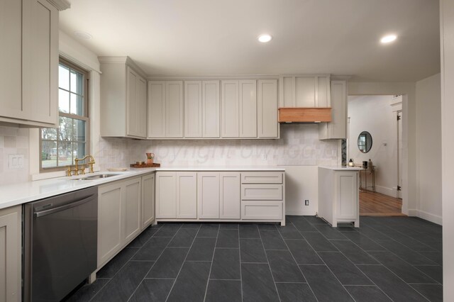 kitchen featuring white cabinets, backsplash, stainless steel dishwasher, and sink