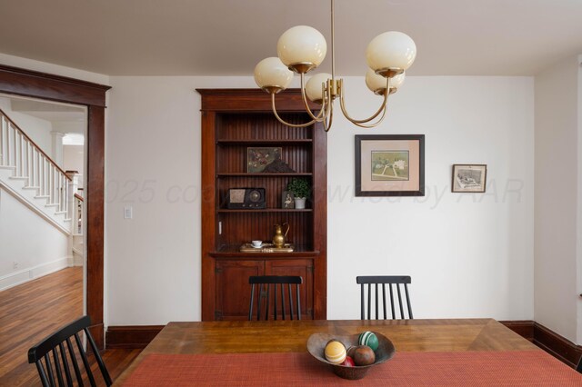 dining area with dark hardwood / wood-style flooring and a chandelier