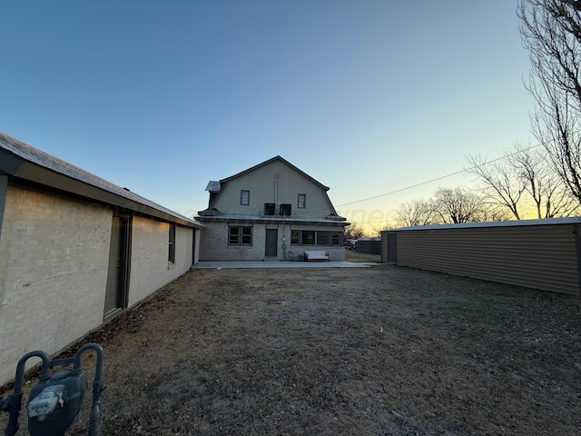 back house at dusk with a patio