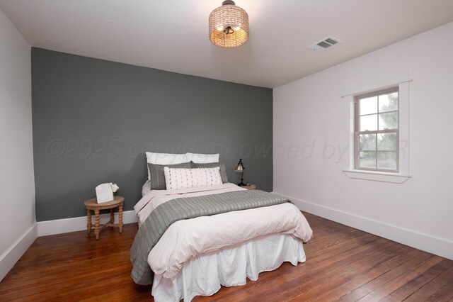 bedroom with dark wood-type flooring