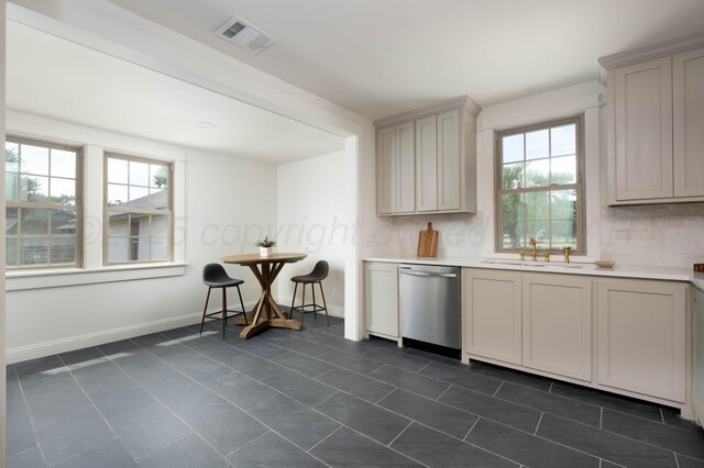 kitchen featuring dishwasher, dark tile patterned floors, sink, and tasteful backsplash