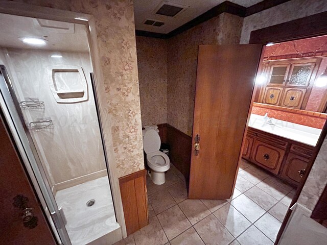 bathroom with toilet, walk in shower, vanity, and tile patterned floors