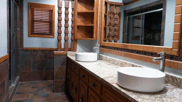 bathroom featuring vanity, an enclosed shower, and tile walls