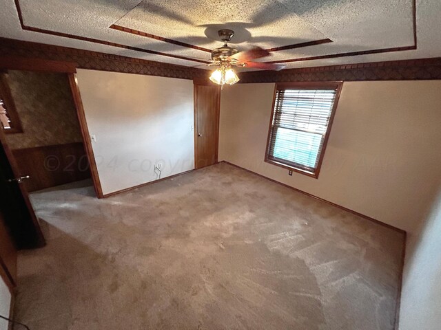 unfurnished bedroom with a textured ceiling, carpet floors, and ceiling fan