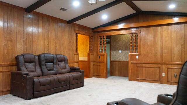 cinema with lofted ceiling with beams, wood walls, and light colored carpet