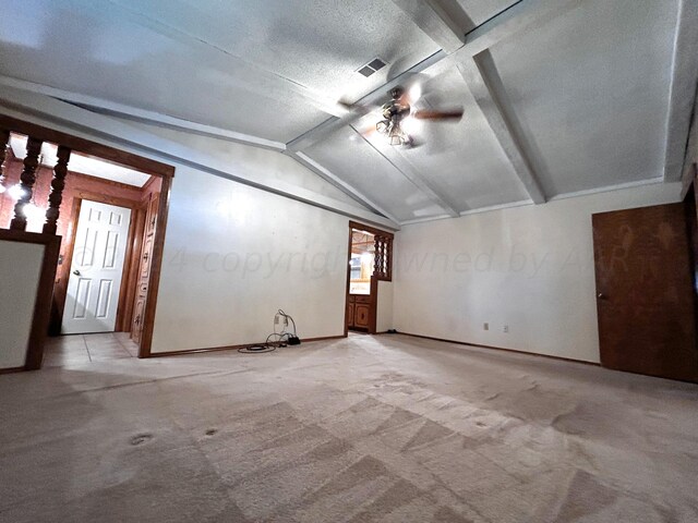 carpeted empty room featuring a textured ceiling and vaulted ceiling with beams