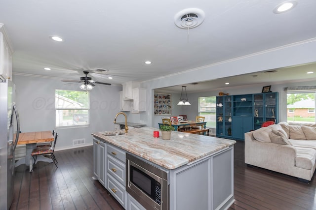 5109 Tawney Ave, Amarillo, TX 79106 - kitchen featuring appliances with stainless steel finishes, crown molding, open floor plan, dark wood-style flooring, and light stone counters