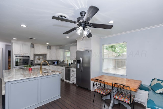 5109 Tawney Ave, Amarillo, TX 79106 - kitchen with appliances with stainless steel finishes, ornamental molding, dark wood-style floors, white cabinetry, and ceiling fan