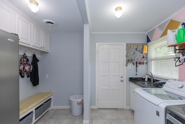 5109 Tawney Ave, Amarillo, TX 79106 - washroom featuring washing machine and clothes dryer, cabinet space, light tile patterned floors, and crown molding