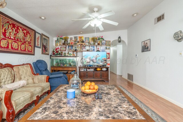 1411 N Highland St, Amarillo, TX 79107 - living room featuring arched walkways, ceiling fan, wood finished floors, and baseboards
