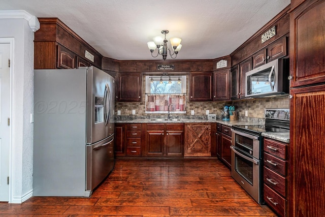 kitchen with stainless steel appliances, dark hardwood / wood-style flooring, a chandelier, light stone counters, and sink