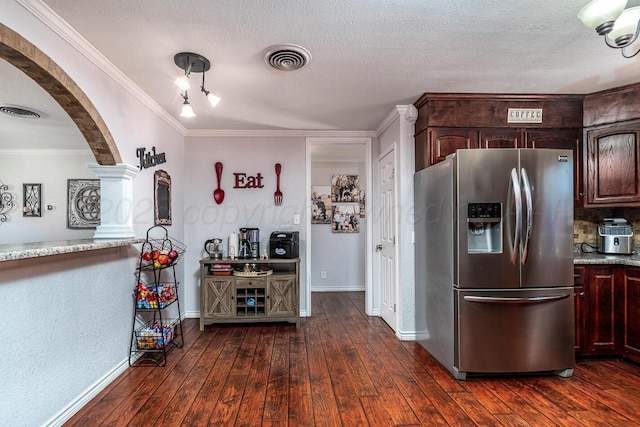 kitchen featuring a textured ceiling, dark brown cabinetry, stainless steel refrigerator with ice dispenser, dark wood-type flooring, and crown molding