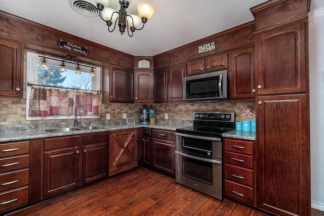 kitchen featuring tasteful backsplash, sink, stainless steel appliances, dark hardwood / wood-style flooring, and a chandelier