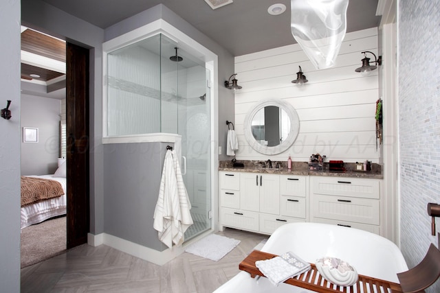 ensuite bathroom with a shower stall, vanity, baseboards, ensuite bathroom, and a soaking tub