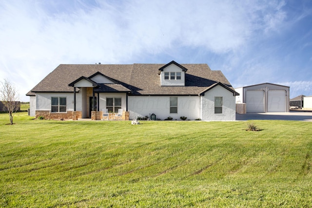 modern inspired farmhouse with a front yard, an outdoor structure, and roof with shingles