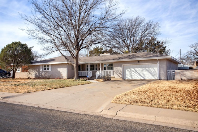 ranch-style home featuring covered porch and a garage