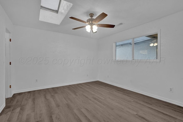 301 Estireno St, Borger, TX 79007 - empty room featuring ceiling fan, visible vents, a skylight, and wood finished floors