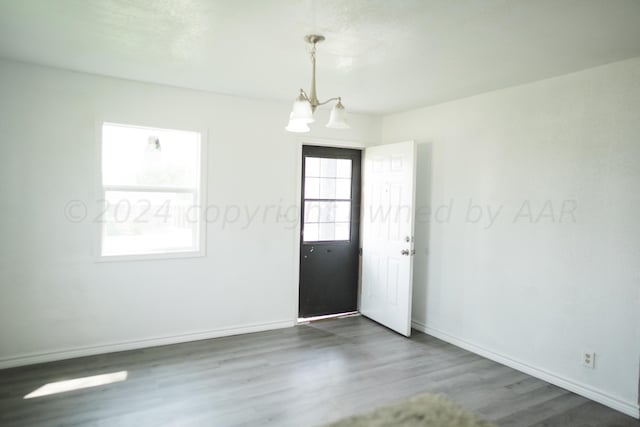 spare room with dark wood-type flooring and a notable chandelier