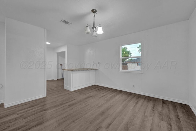 301 Estireno St, Borger, TX 79007 - interior space with baseboards, a chandelier, visible vents, and wood finished floors