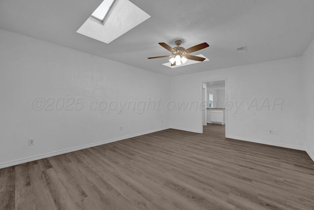 301 Estireno St, Borger, TX 79007 - empty room featuring dark wood-type flooring, baseboards, and a skylight