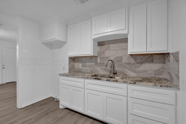 301 Estireno St, Borger, TX 79007 - kitchen with white cabinets, visible vents, light stone counters, and a sink