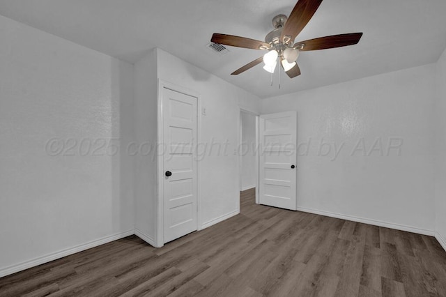 301 Estireno St, Borger, TX 79007 - unfurnished bedroom with baseboards, ceiling fan, visible vents, and wood finished floors