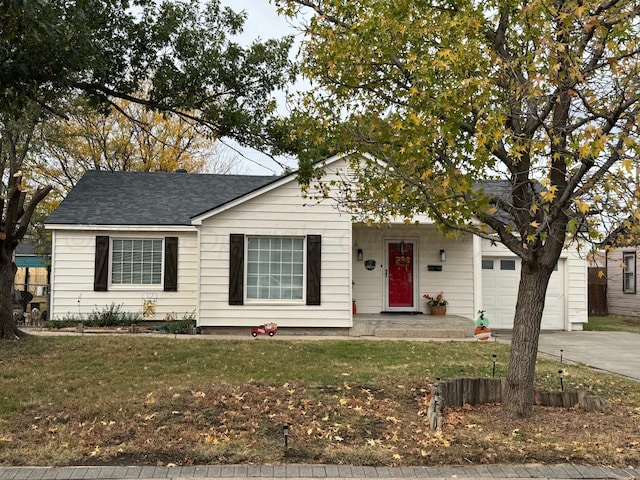 single story home featuring an attached garage, roof with shingles, concrete driveway, and a front yard