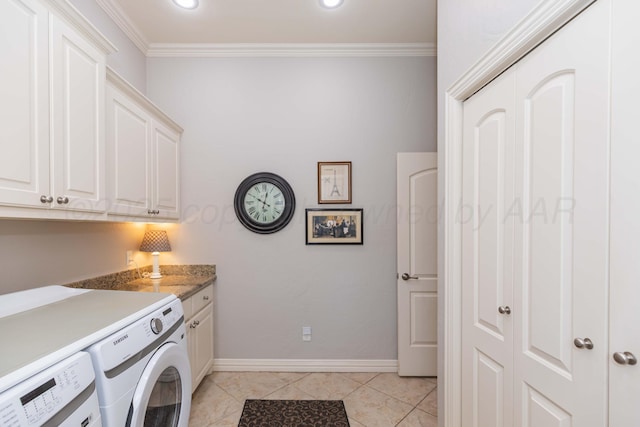 clothes washing area featuring washing machine and clothes dryer, baseboards, cabinet space, crown molding, and light tile patterned floors