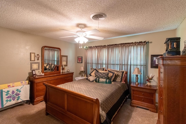 carpeted bedroom featuring ceiling fan and a textured ceiling