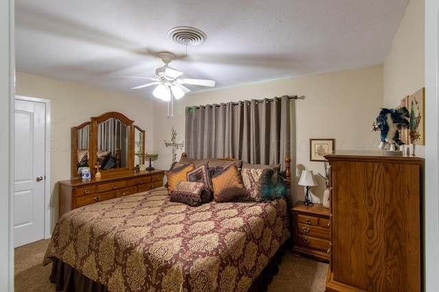 carpeted bedroom with a textured ceiling and ceiling fan