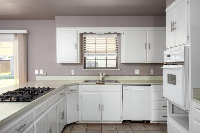 505 Alamo St, Claude, TX 79019 - kitchen featuring white appliances, a sink, white cabinets, light countertops, and light tile patterned flooring