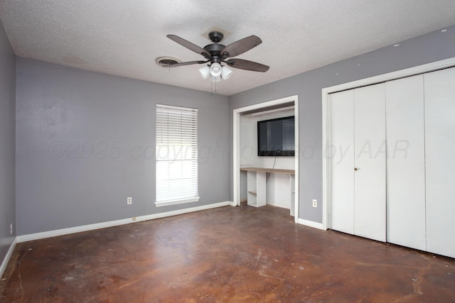 505 Alamo St, Claude, TX 79019 - unfurnished bedroom featuring finished concrete flooring, baseboards, a textured ceiling, a ceiling fan, and a closet