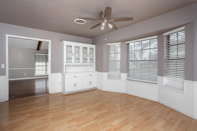 505 Alamo St, Claude, TX 79019 - empty room with wainscoting, a ceiling fan, and light wood finished floors
