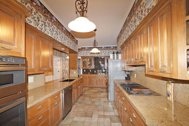 2101 S Harrison St, Amarillo, TX 79109 - kitchen with a sink, stainless steel appliances, backsplash, brown cabinets, and light stone counters