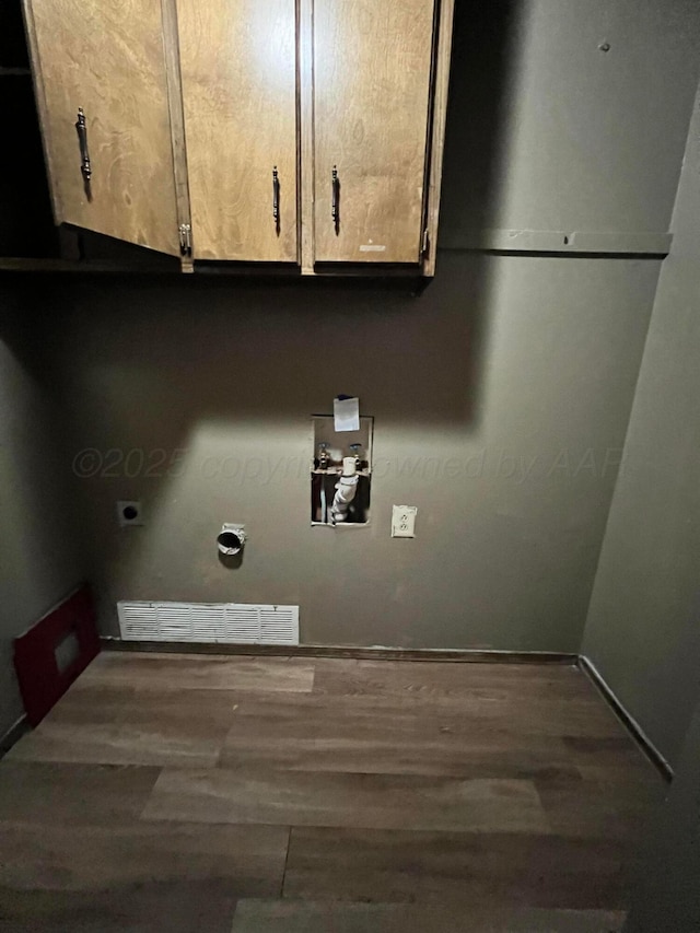 laundry room with electric dryer hookup, washer hookup, dark hardwood / wood-style flooring, and cabinets