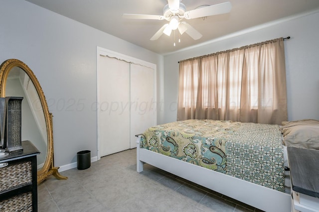tiled bedroom with a closet, baseboards, and ceiling fan