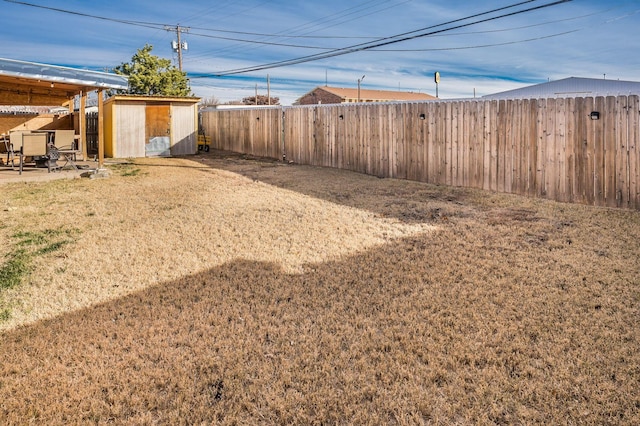 view of yard with a storage shed, an outdoor structure, a fenced backyard, and a patio area