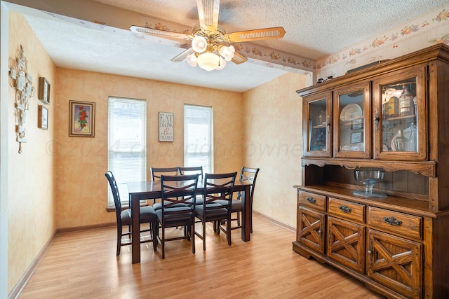 dining area with light hardwood / wood-style flooring, a textured ceiling, and ceiling fan