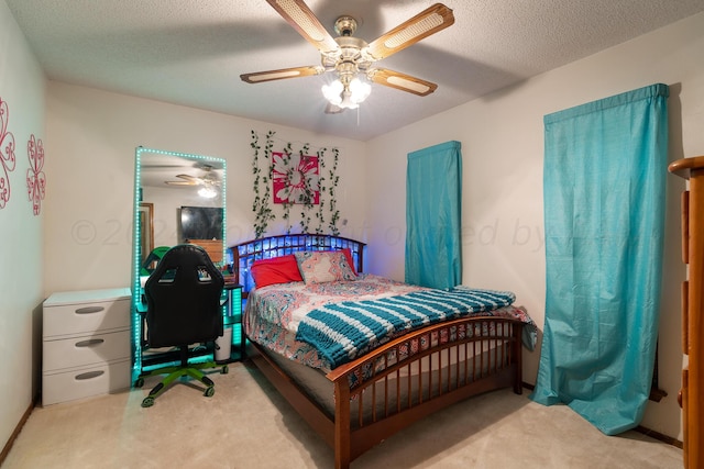 bedroom featuring a textured ceiling, light carpet, and ceiling fan