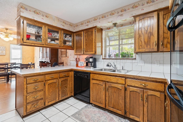 kitchen featuring light tile patterned floors, plenty of natural light, sink, and black dishwasher