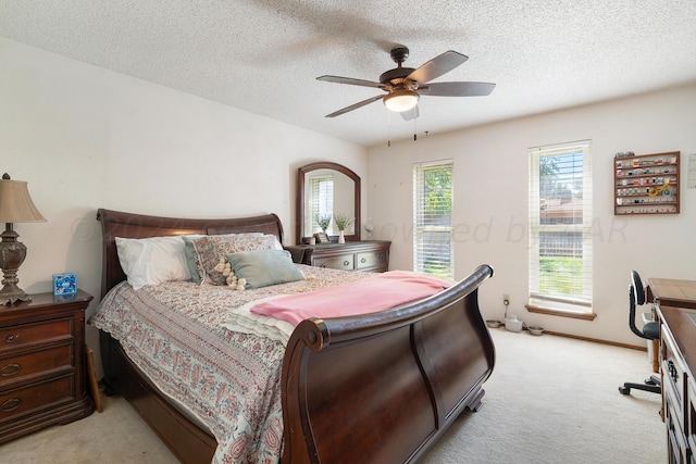 bedroom featuring ceiling fan, a textured ceiling, and light colored carpet