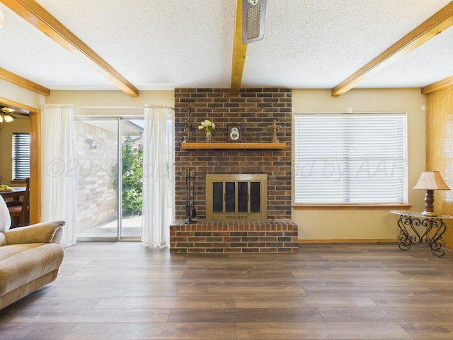 1620 N Nelson St, Pampa, TX 79065 - living area with beamed ceiling, a textured ceiling, hardwood / wood-style flooring, and a fireplace