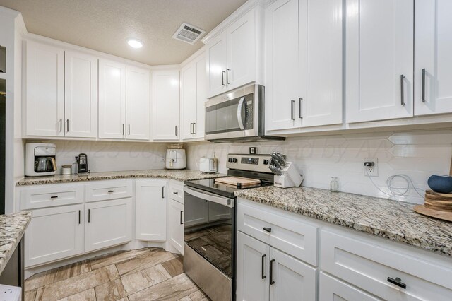 8309 City View Dr, Amarillo, TX 79118 - kitchen with appliances with stainless steel finishes, white cabinets, decorative backsplash, light stone countertops, and recessed lighting