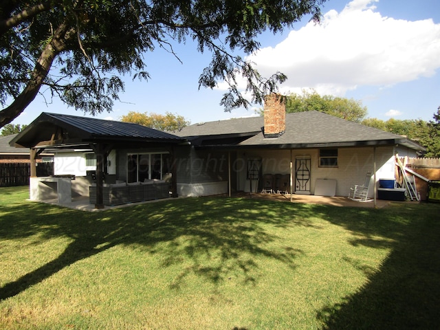 rear view of house featuring a lawn and a patio