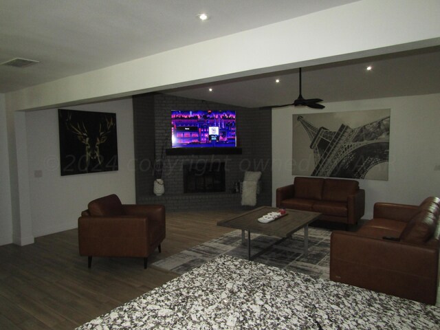 living room featuring hardwood / wood-style floors, a fireplace, and ceiling fan