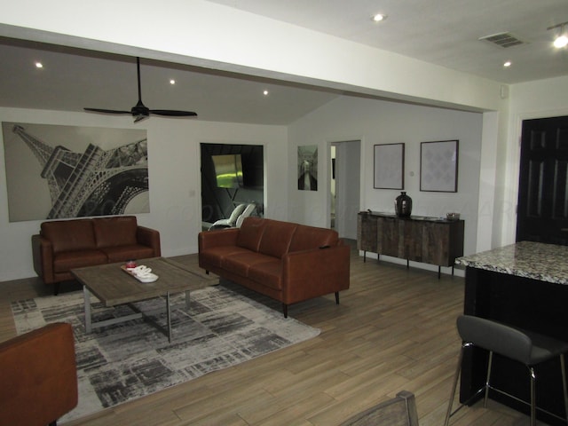 living room with ceiling fan, wood-type flooring, and vaulted ceiling