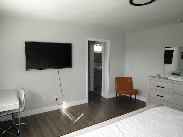 bedroom with dark wood-type flooring and ensuite bath