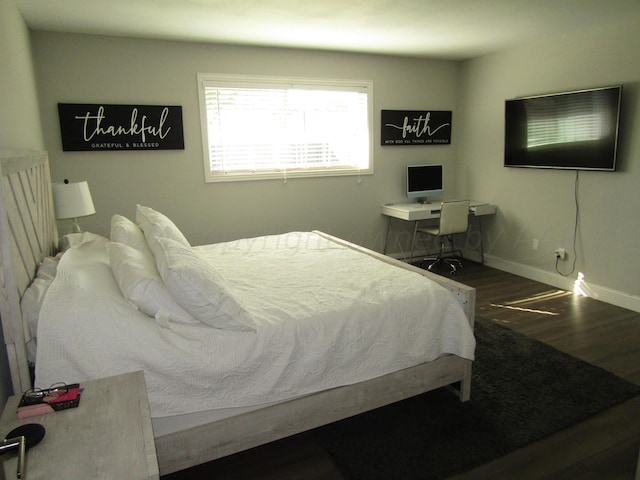 bedroom with dark hardwood / wood-style flooring