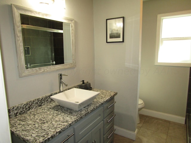 bathroom with vanity, tile patterned floors, toilet, and walk in shower