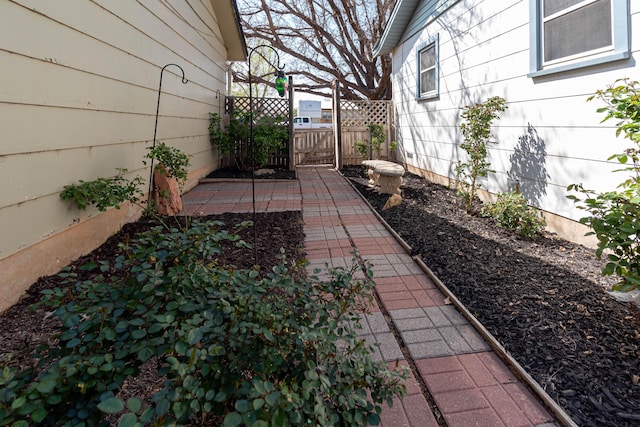 view of yard featuring a patio, fence, and a gate